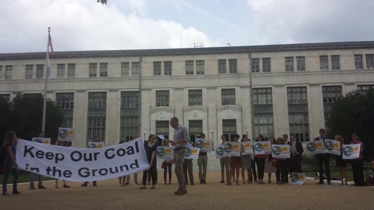 A group of activists holding a banner that says "Keep Our Coal in the Ground" and signs that say "Fair Share for Taxpayers"