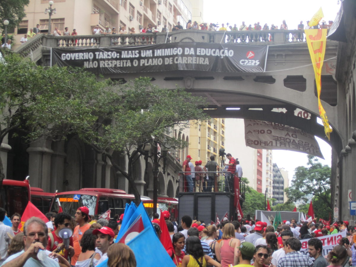Protestors standing on top of and underneath a bridge
