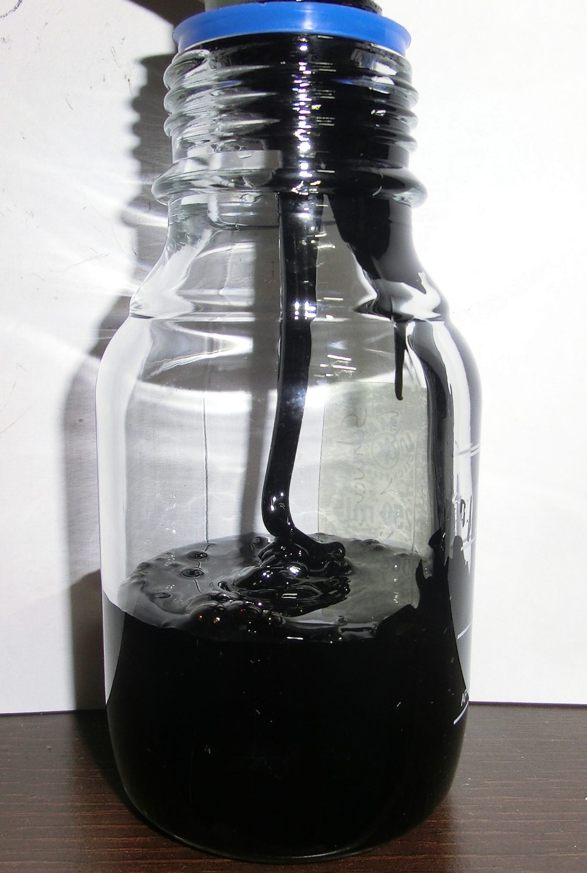 A black substance pouring into a beaker