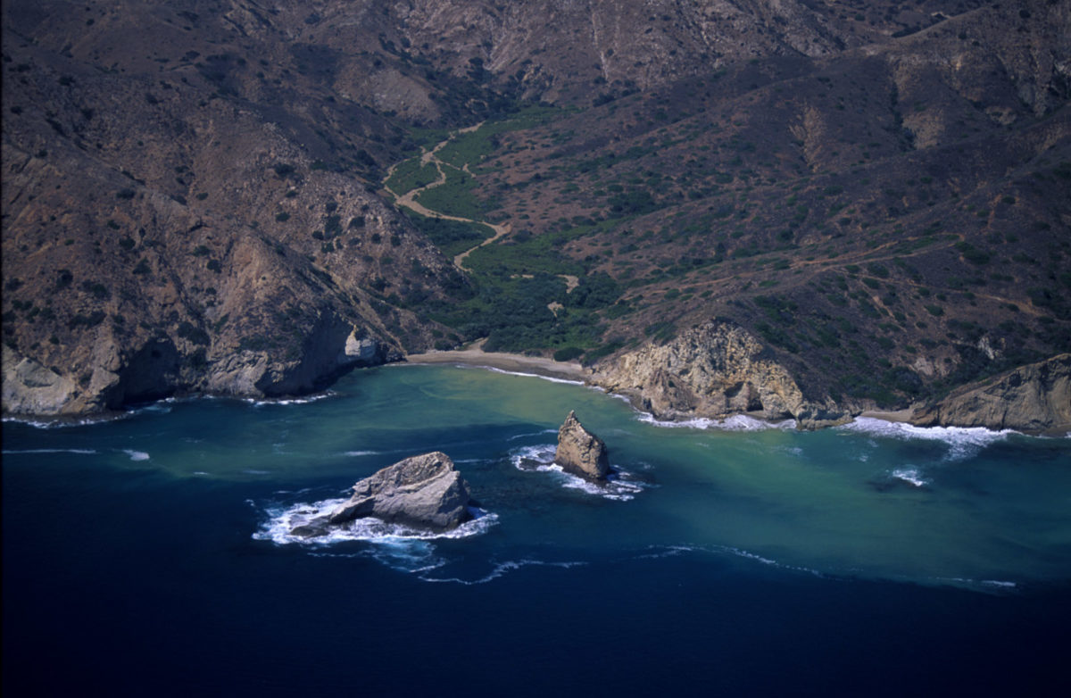 Rock formations in the water near mountains