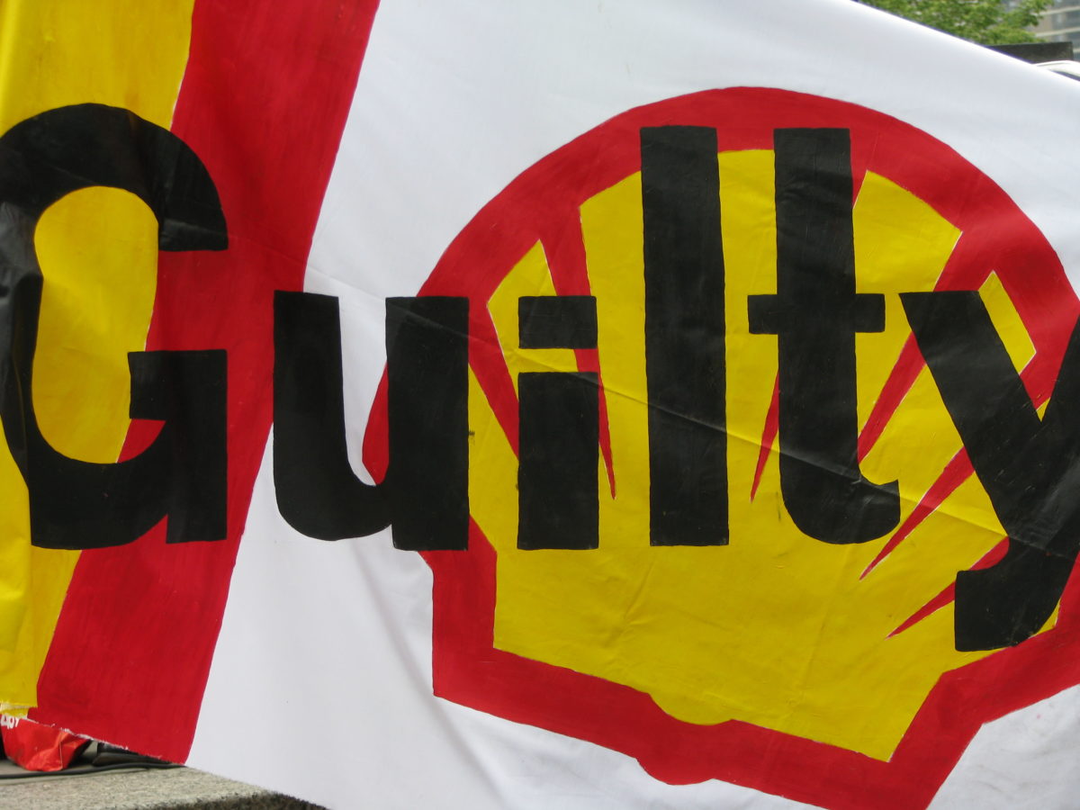 A hand painted banner with the word "Guilty" written over Shell Gasoline logo