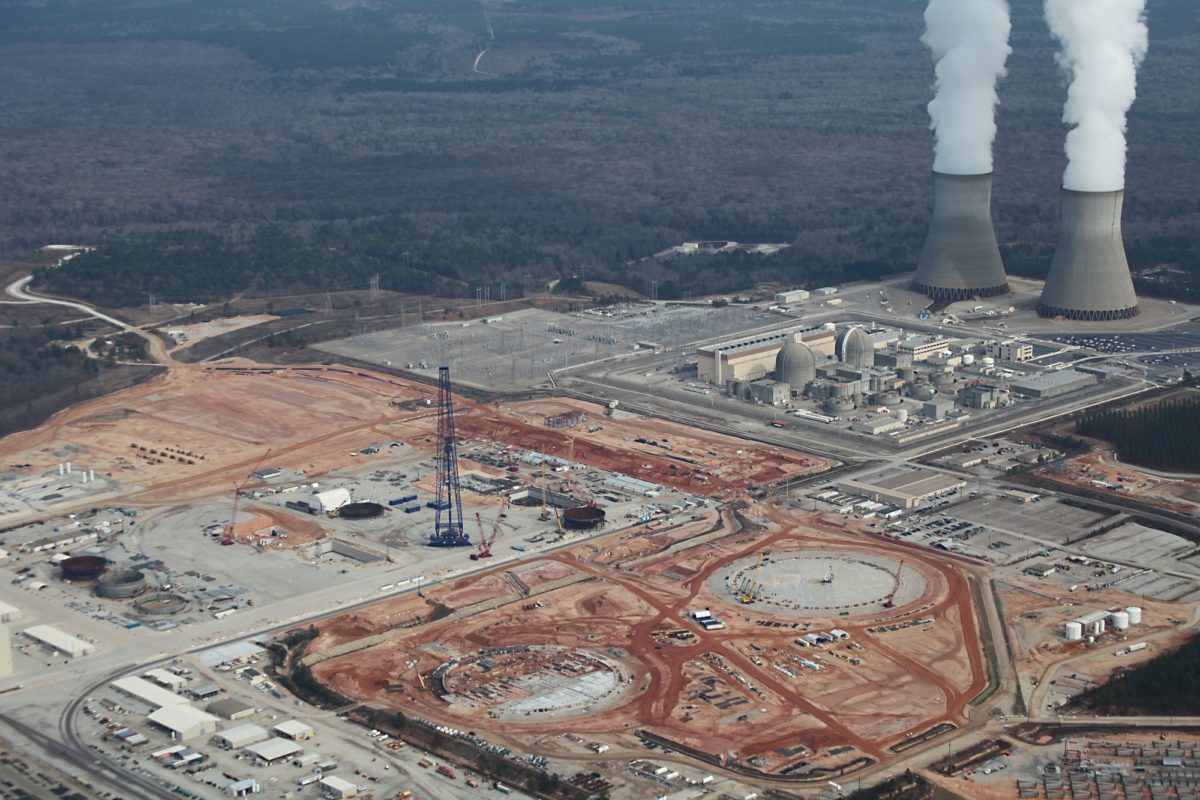 Overhead shot of a nuclear plant with two nuclear reactors in the background