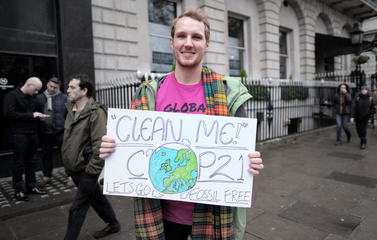 An activist holding a sign against fossil fuels