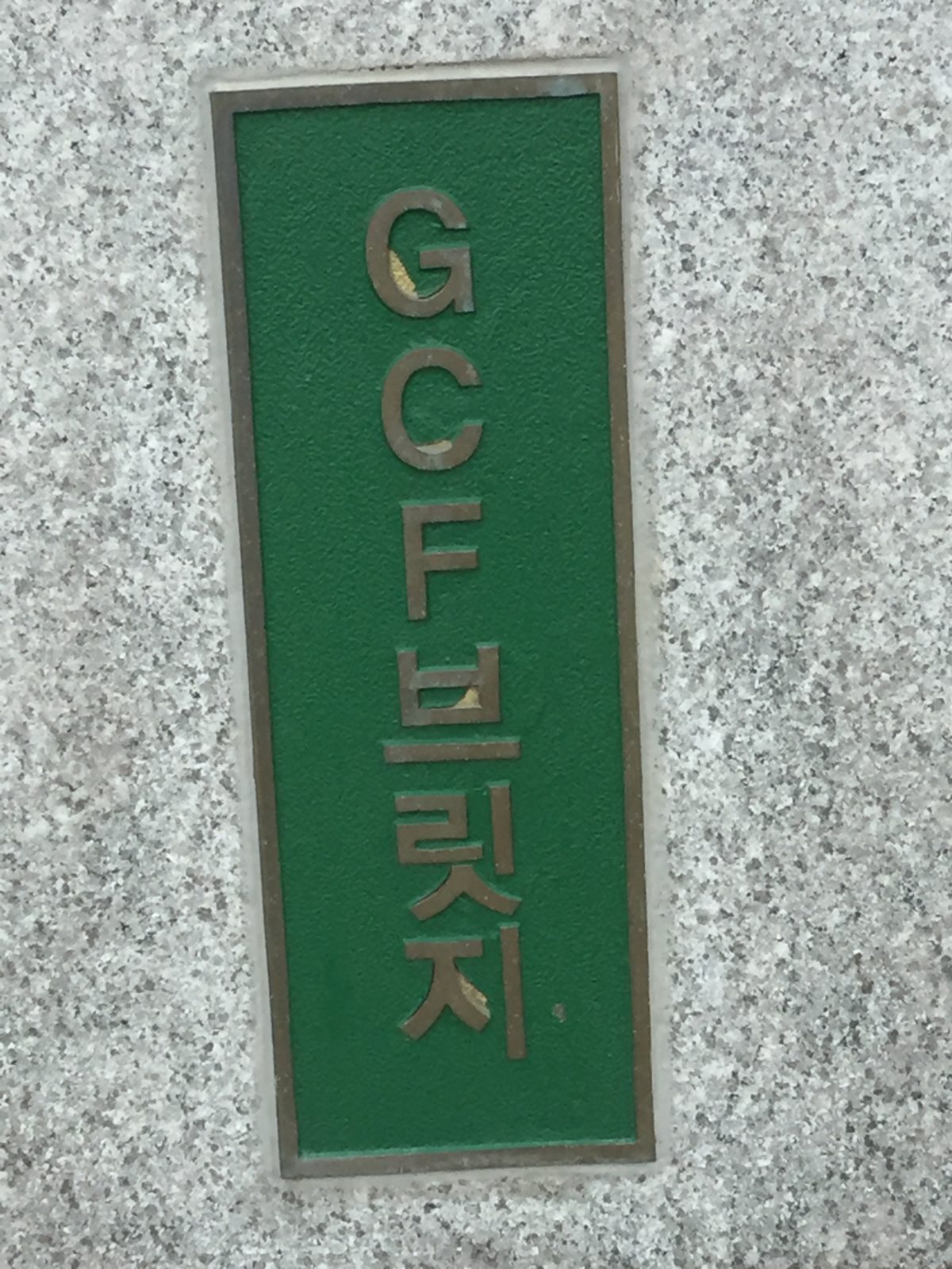 A green wall sign that says "GCF"