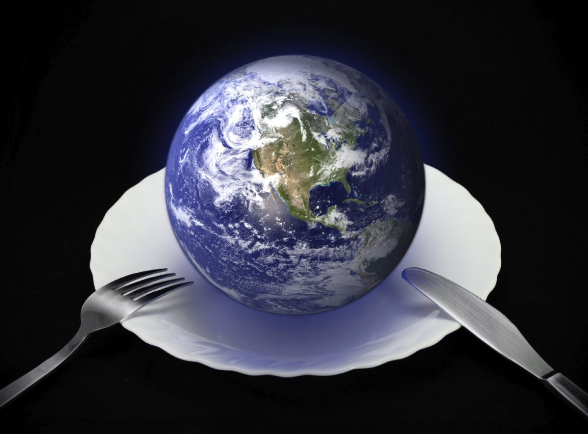 The Earth on a dinner plate with a fork and knife
