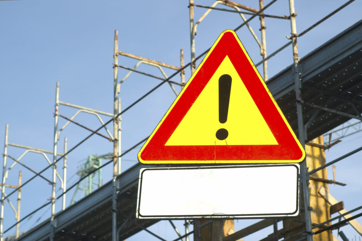 A yellow warning sign with an exclamation point in the center and a red border