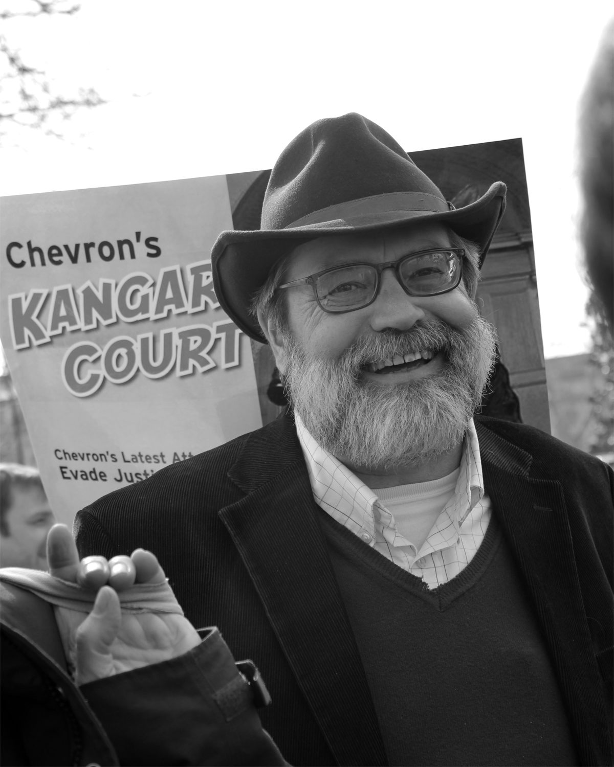 An activist standing in front of a sign about Chevron