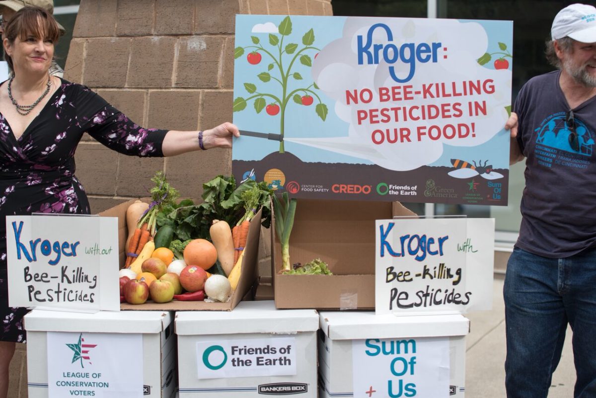 Activists holding a sign against Kroger using selling food made with bee killing pesticides