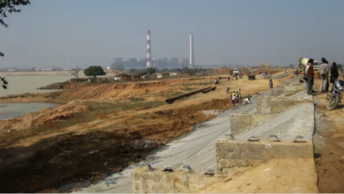 A dirt road leading up to a factory