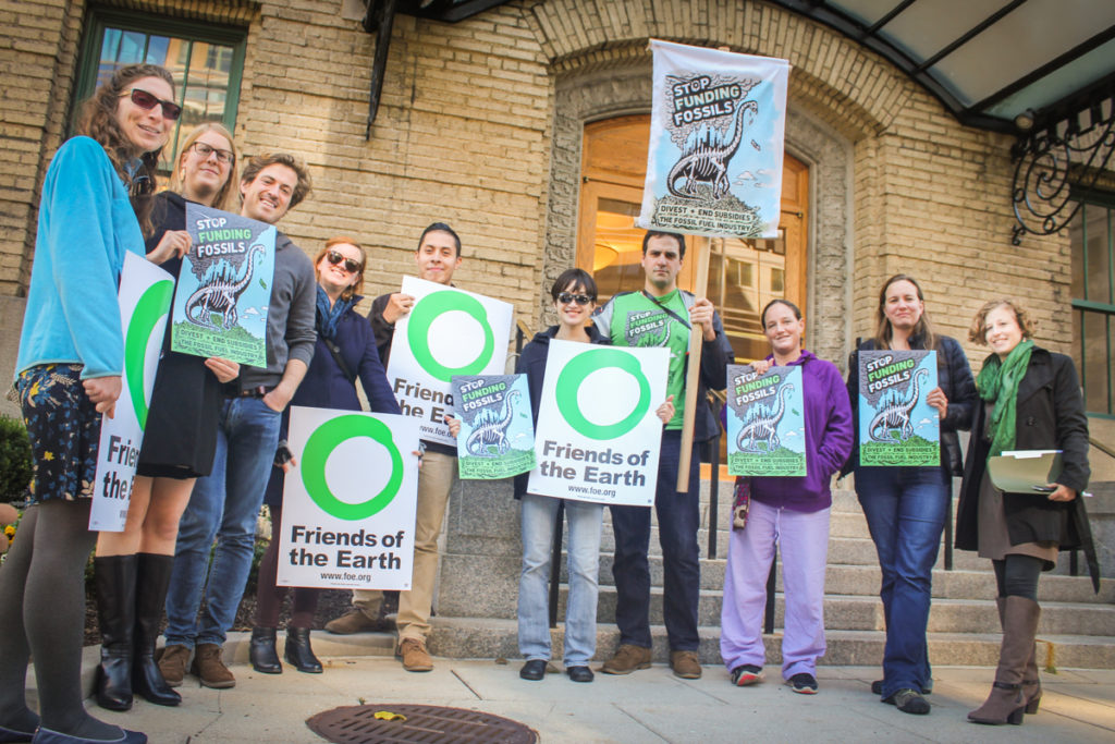 A group of activists holding Friends of the Earth and anti fossil fuel signs