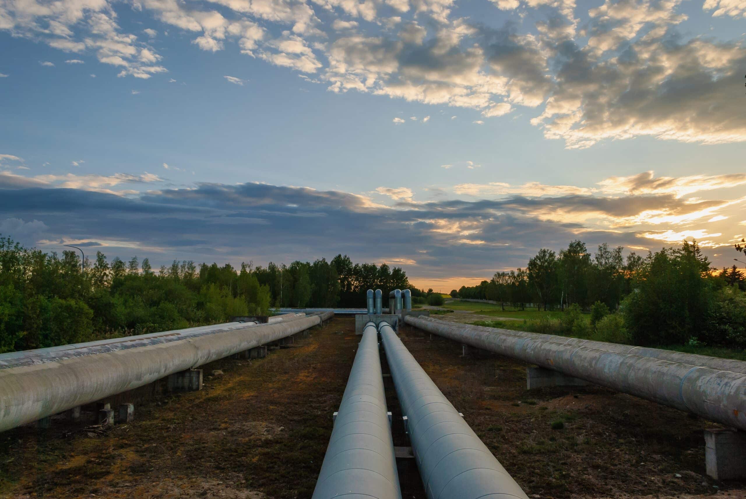 May contain large industrial pipes under a cloudy sky at sunset.