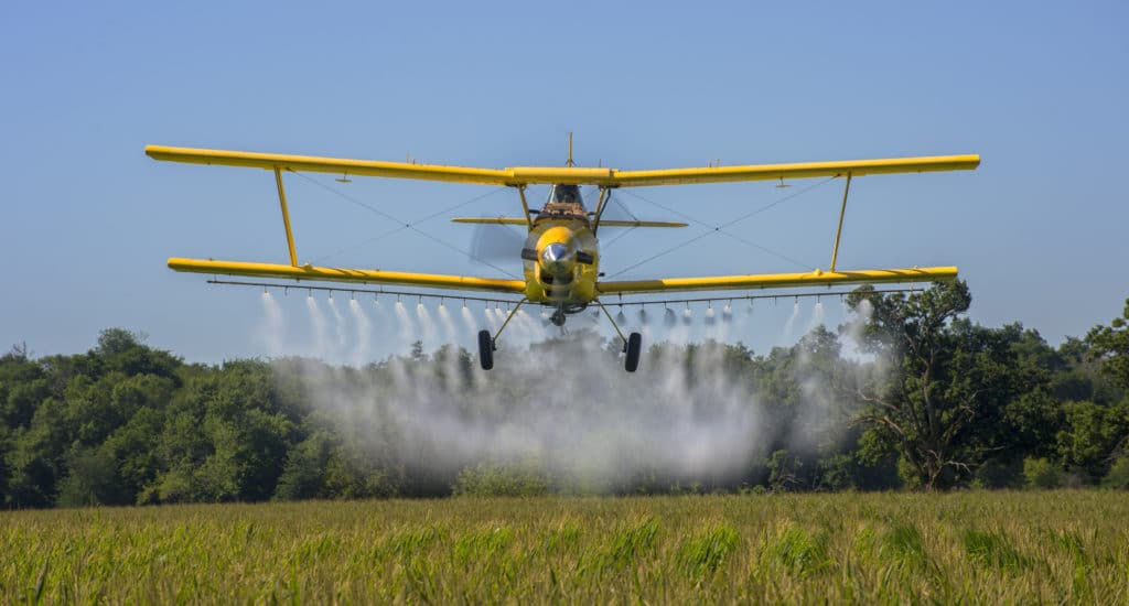 Small Plane Spraying Pesticides on Crops