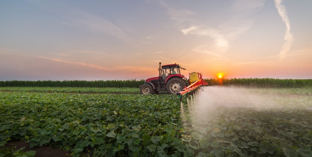 A tractor spraying crops with pesticides