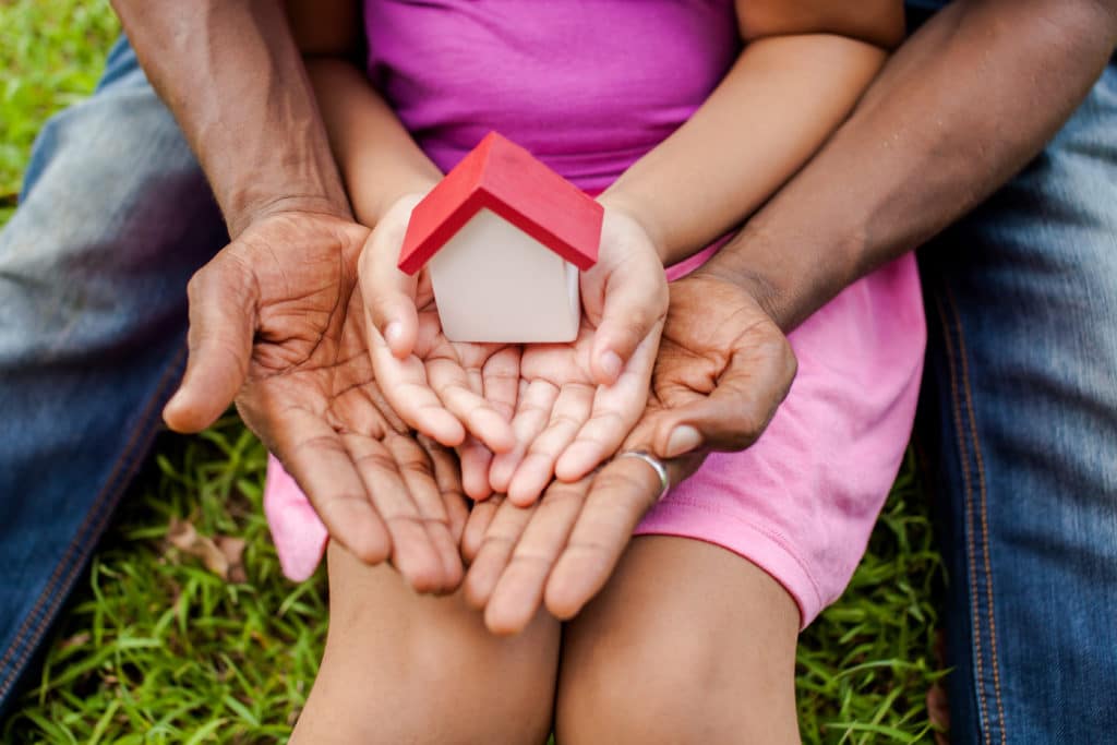 Hands of Family Together Holding House in Green Park
