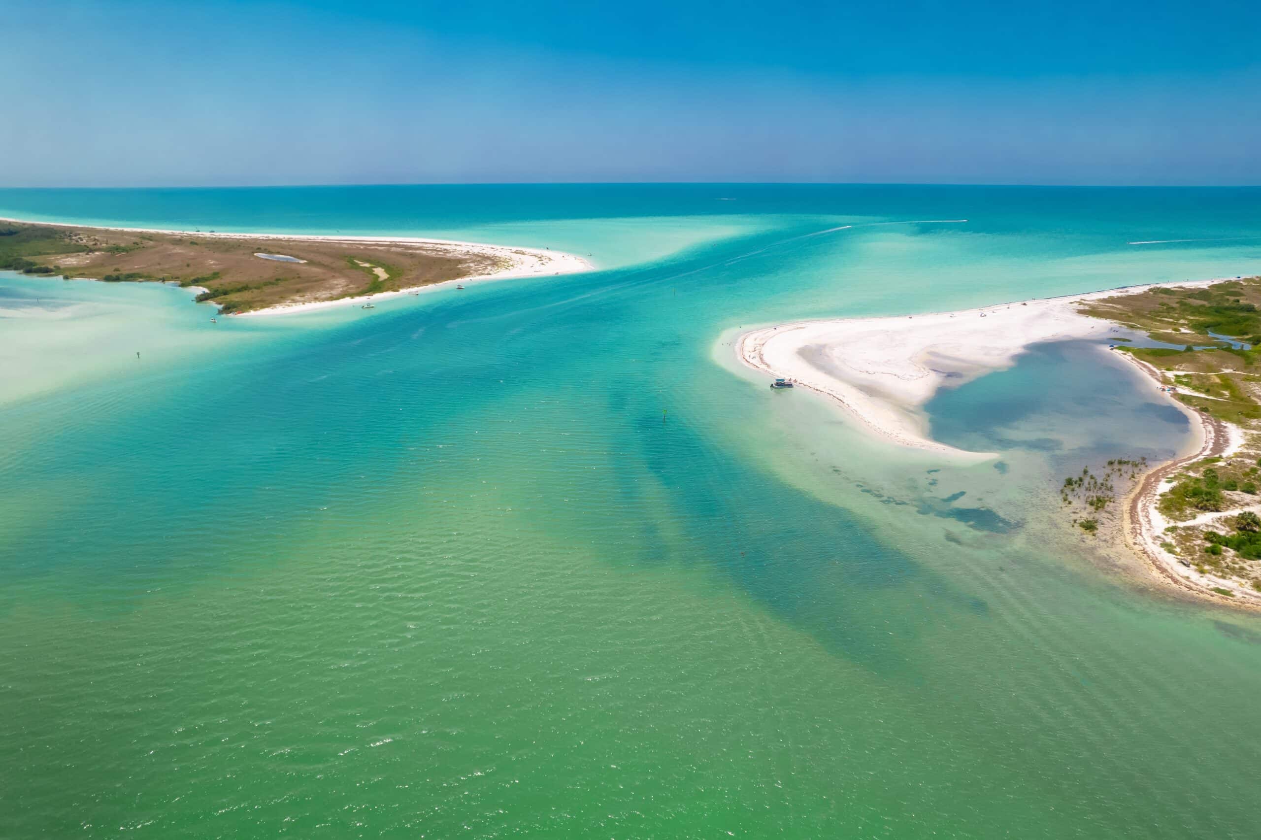 May contain a boat and several people on a sandy beach.