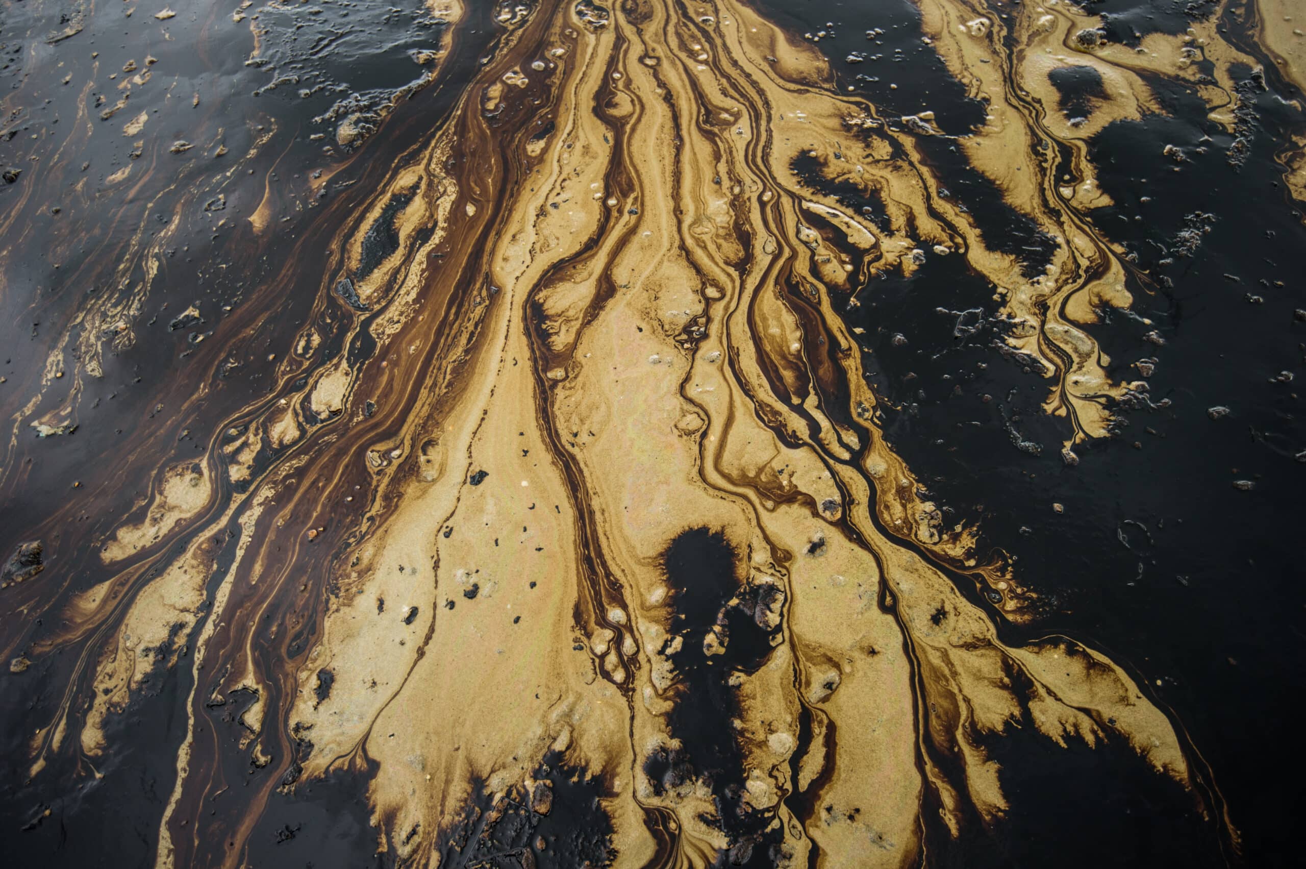 May contain oil and water on a sandy surface.