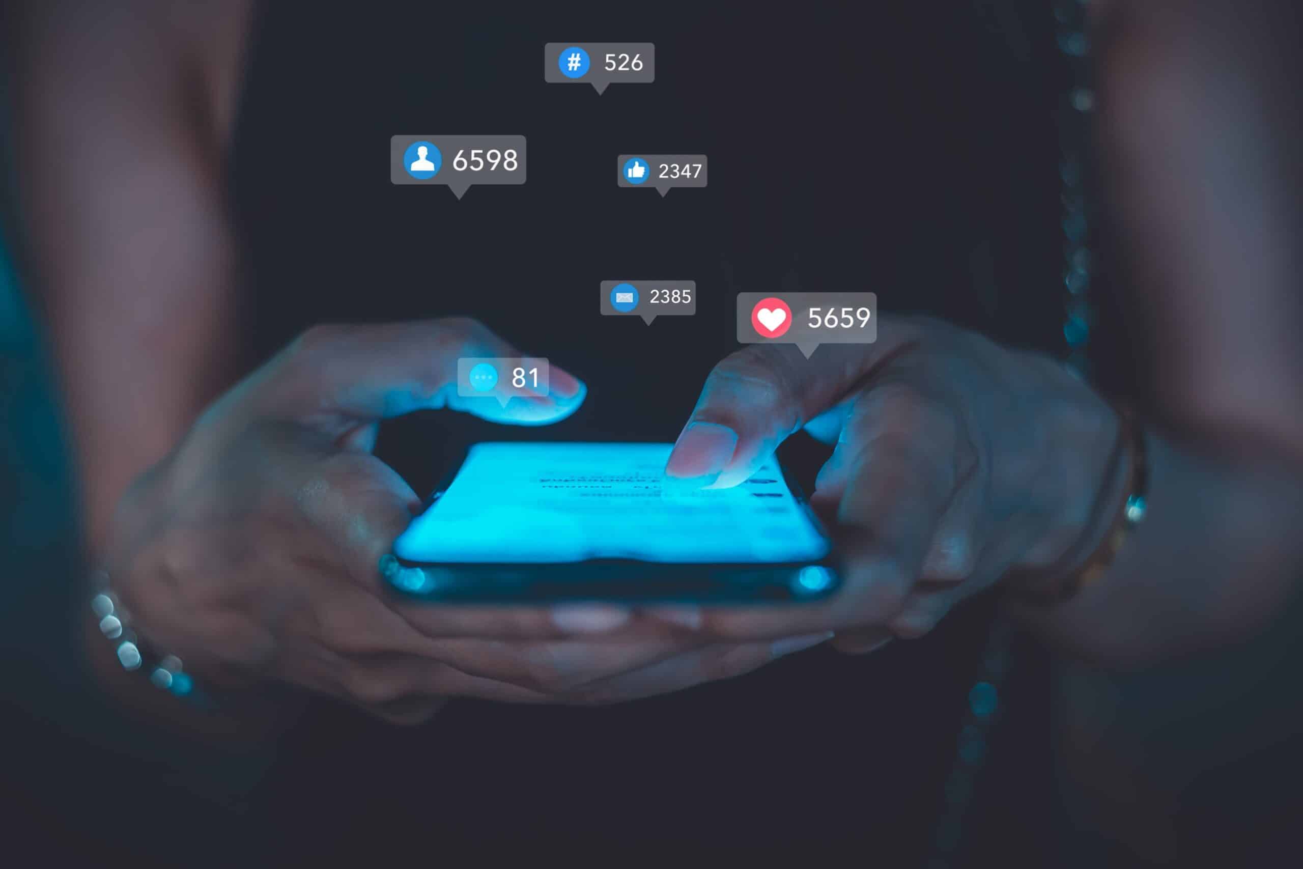 May contain a person's hands holding a phone with social media notifications.