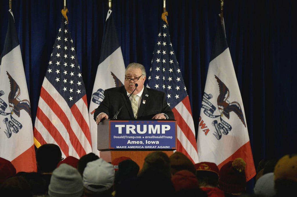 A person standing behind a podium with a Trump sign on it