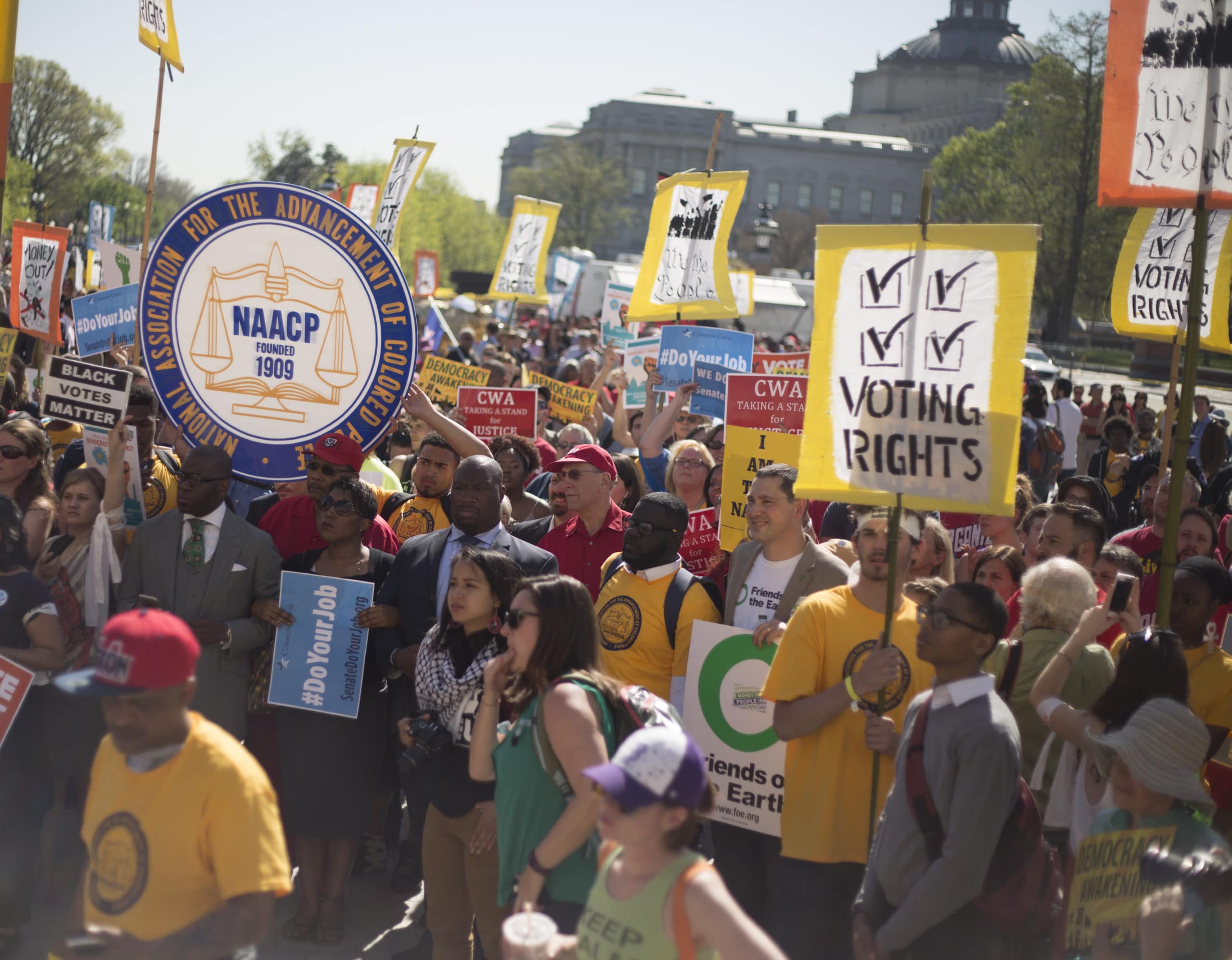 A large group of activists holding signs supporting voting rights