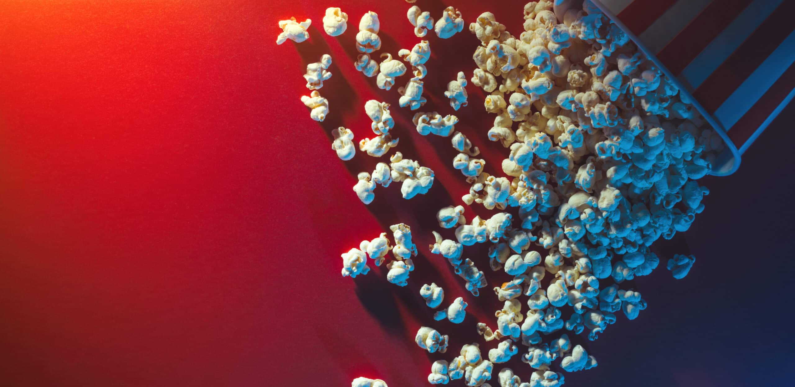 Spilled popcorn on a red surface.