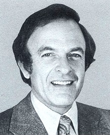 May contain one person smiling wearing a suit and tie.
