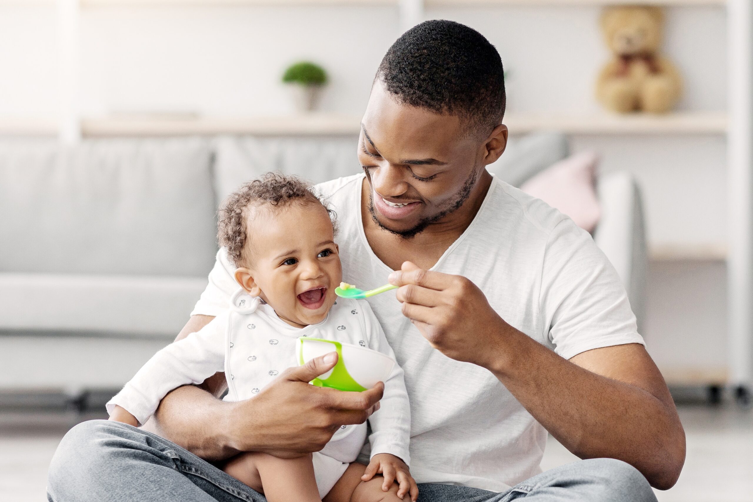 May contain one person feeding a baby from a bowl with a spoon.