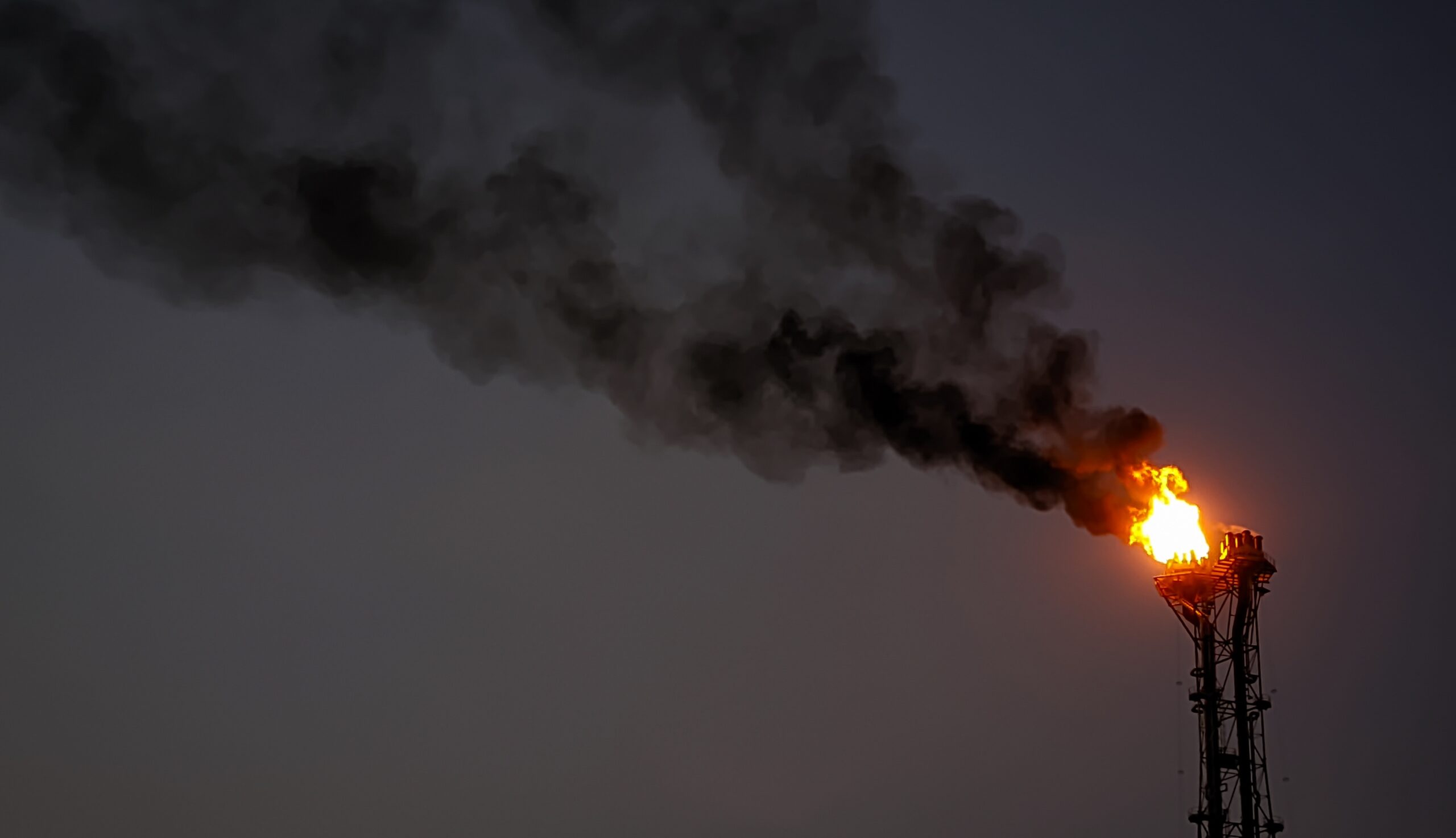 May contain a tall industrial flare with black smoke and fire.