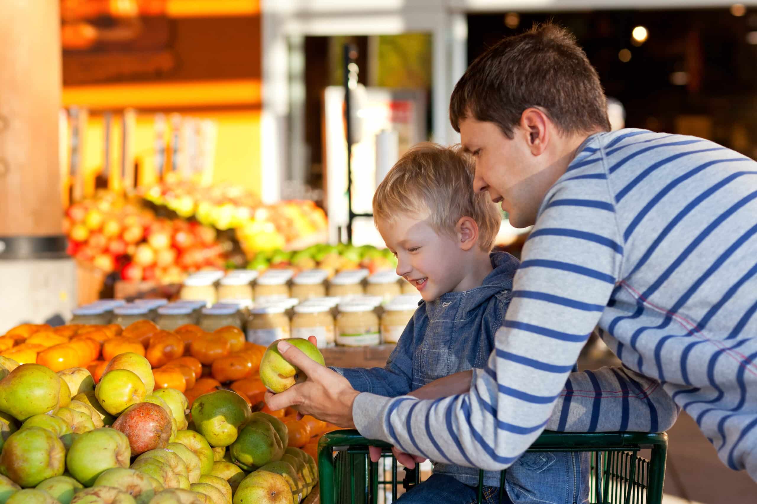 May contain two people looking at fruit at a market.