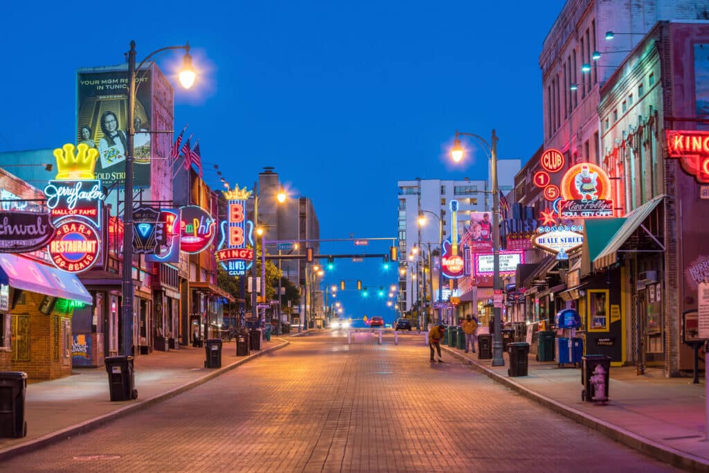 May contain a street scene at night with neon signs and two people.