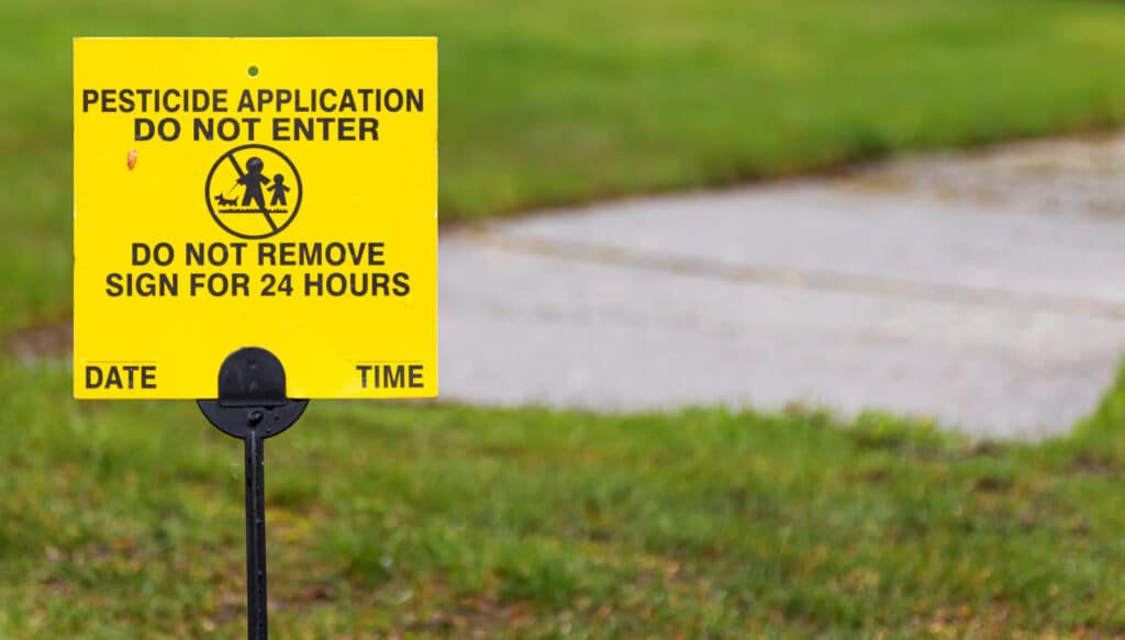 May contain a yellow sign with "Pesticide Application Do Not Enter" and a symbol.