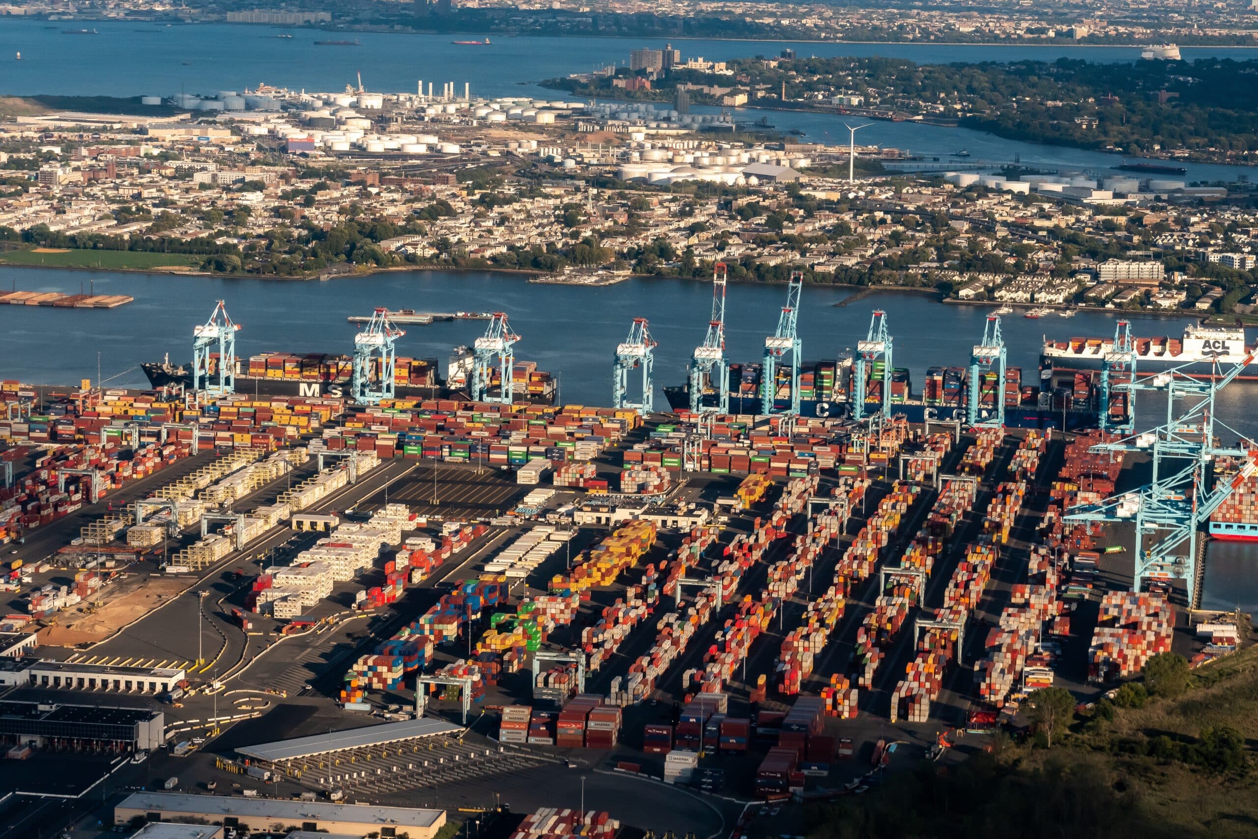 May contain an aerial view of a busy shipping port with stacks of colorful containers.