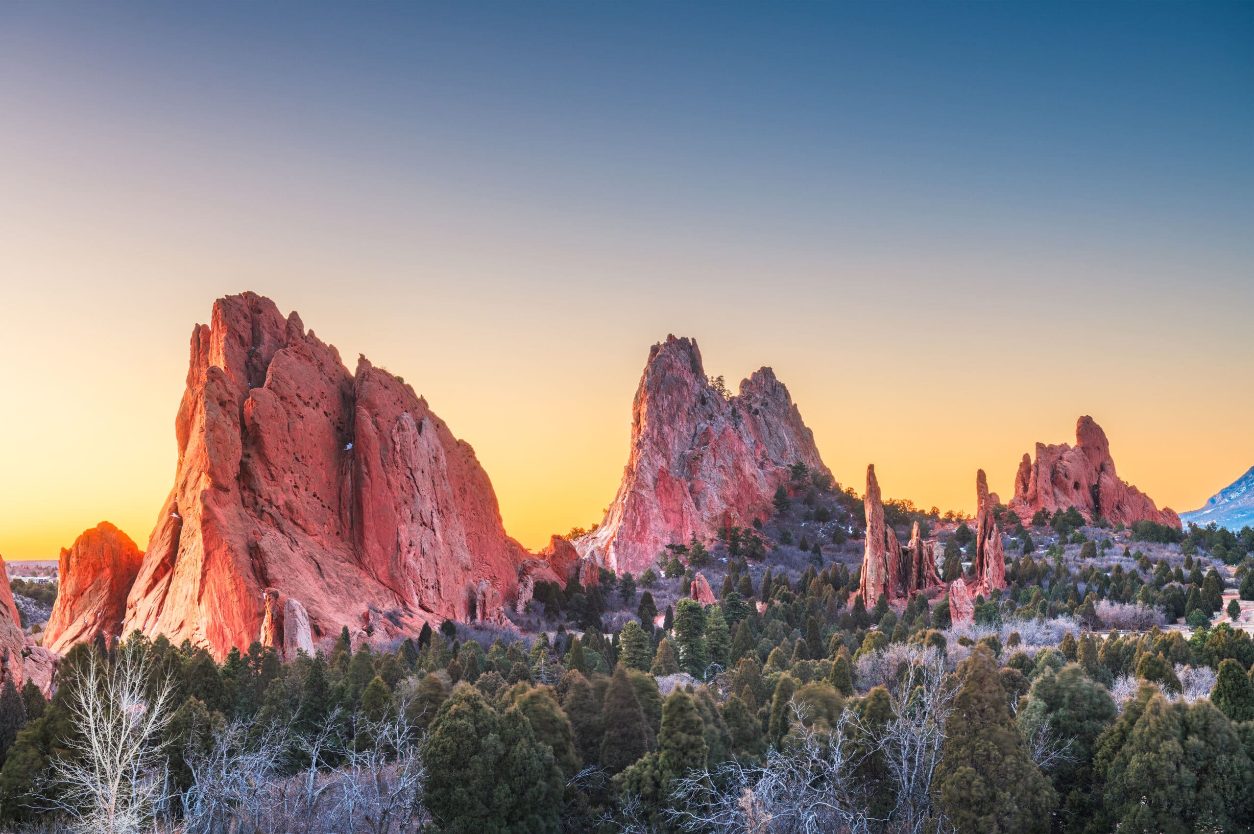 May contain red rock formations with trees and a sunset sky.