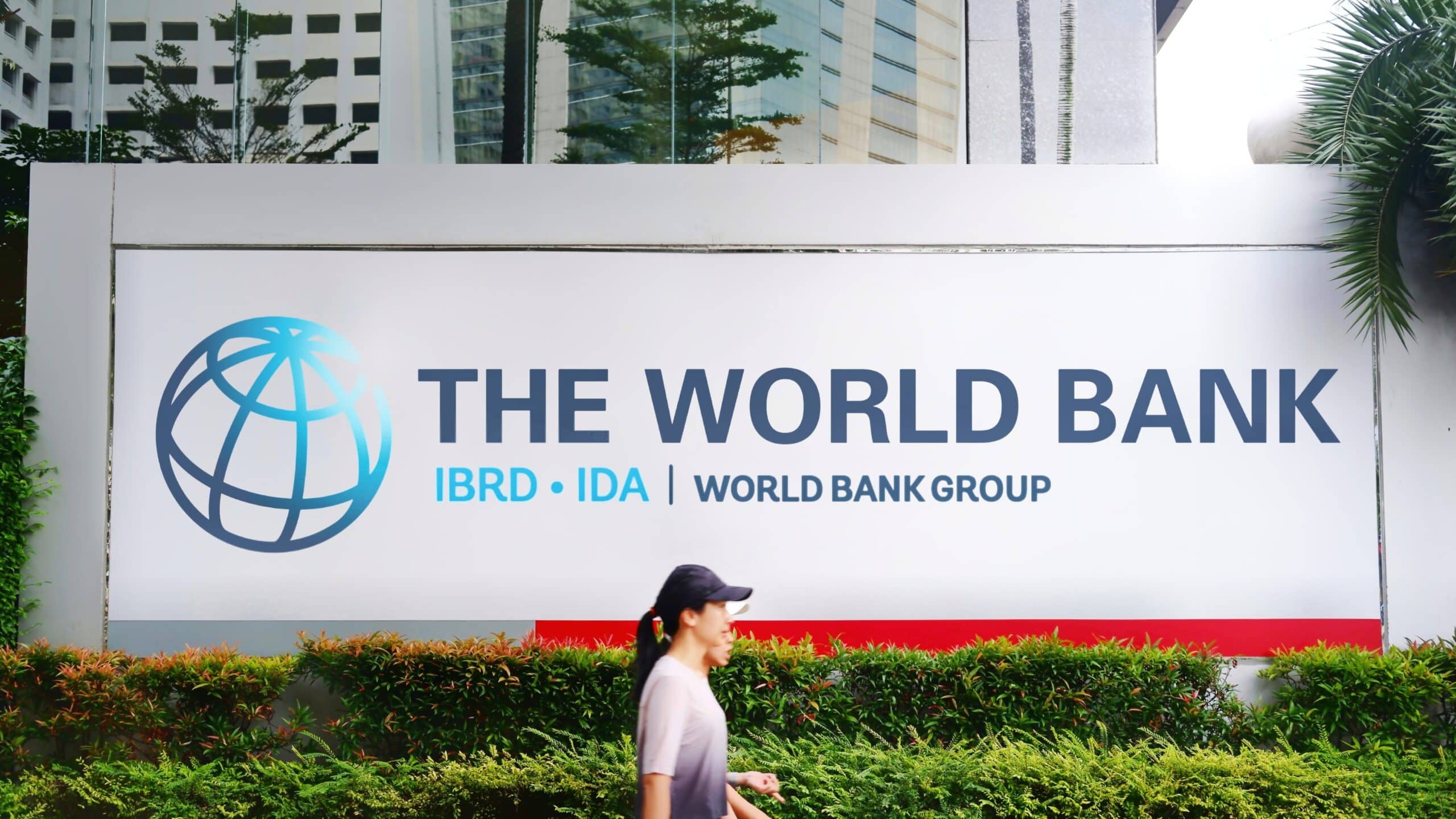 May contain a person walking by a World Bank sign.