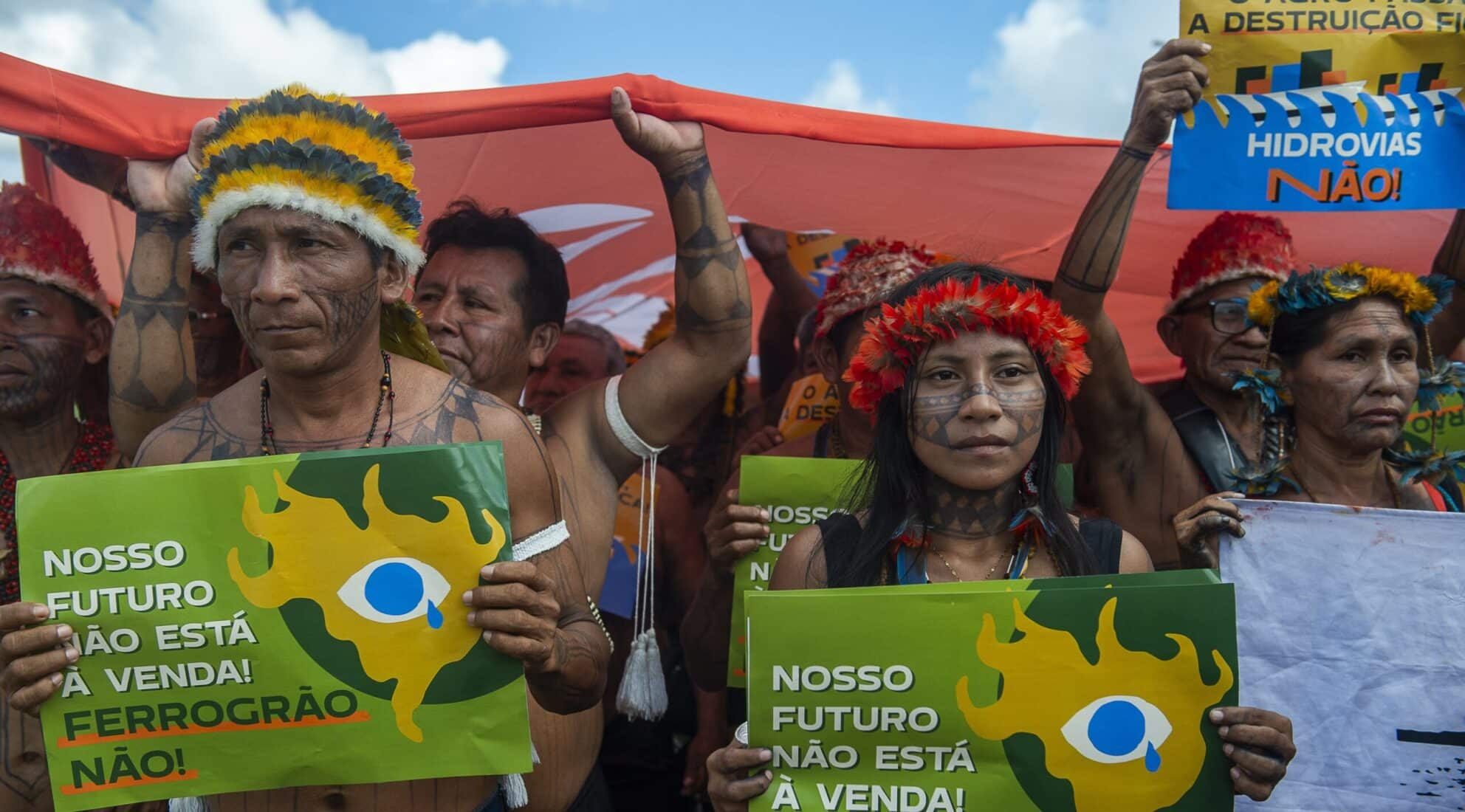 May contain people protesting with signs, some wearing traditional headdresses and face paint.