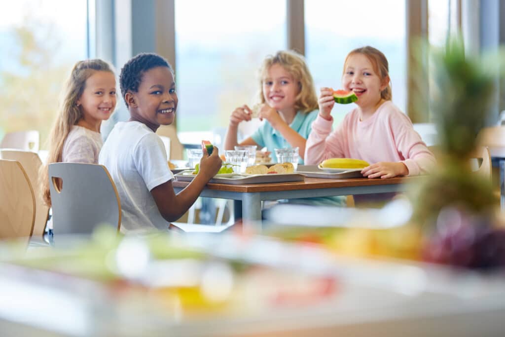 May contain four people eating at a table with food.